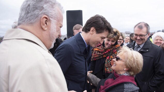 Justin Trudeau prend dans ses bras Colette Roy-Laroche pendant que Philippe Couillard regarde la scène.