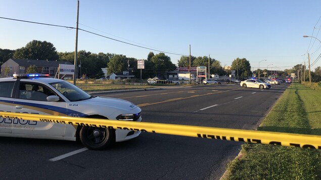 Une voiture de police près du périmètre de sécurité.