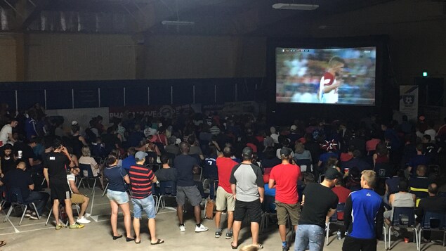 200 personnes sont réunies et regardent le match sur un écran géant. 200 personnes sont réunies et regardent le match sur un écran géant.