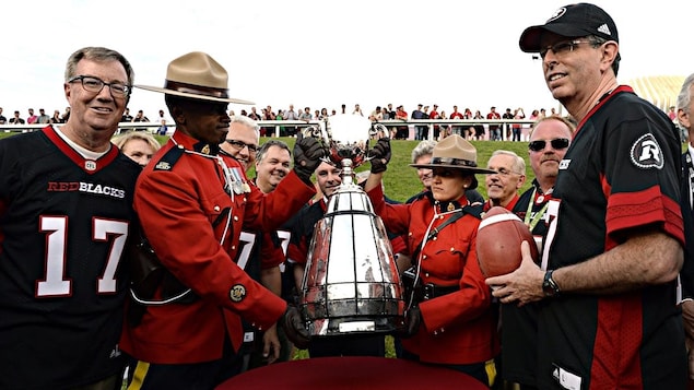 Le maire d'Ottawa, Jim Watson (à g.) et l'ancien joueur des Rough Riders d'Ottawa, Tony Gabriel (à dr.) avec la Coupe Grey. Le maire d'Ottawa, Jim Watson (à g.) et l'ancien joueur des Rough Riders d'Ottawa, Tony Gabriel (à dr.) avec la Coupe Grey.
