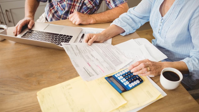 Un couple examinant des documents financiers sur une table.
