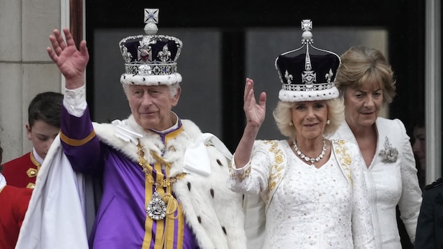 El rey y la reina saludan a la multitud.
