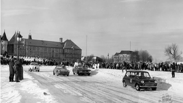 Des voitures font la course sur la piste glacée des plaines durant le Grand Prix Esso, sous le regard de la foule.