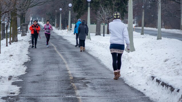 Des piétons et une coureuse sur une piste cyclable d'Ottawa.