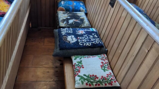Des coussins du monde entier ornent les bancs de l’église historique de Barachois