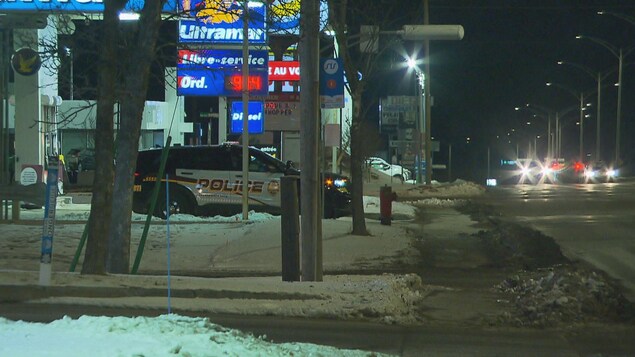 Un véhicule de police stationné en bordure du boulevard à Chicoutimi.