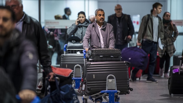 Des passagers entrent dans la zone d'arrivée à Montréal d'un vol d'Air Canada en provenance du Maroc.