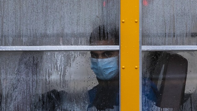 Un élève masqué dans un autobus.