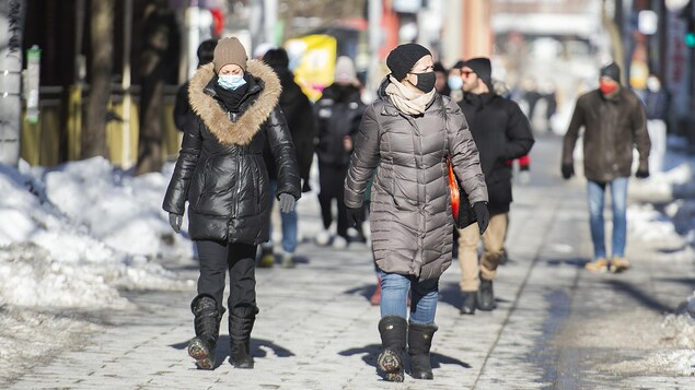 Des gens marchent sur une rue piétonne.