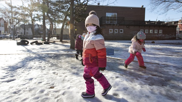 De jeunes élèves qui jouent dans la cour d'école en hiver.