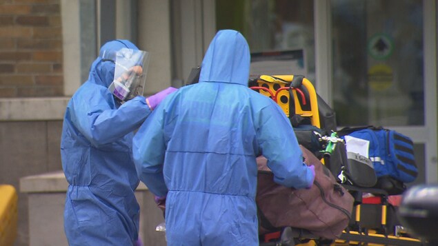 Du personnel de soin est en train rentrer une civière à l'urgence.