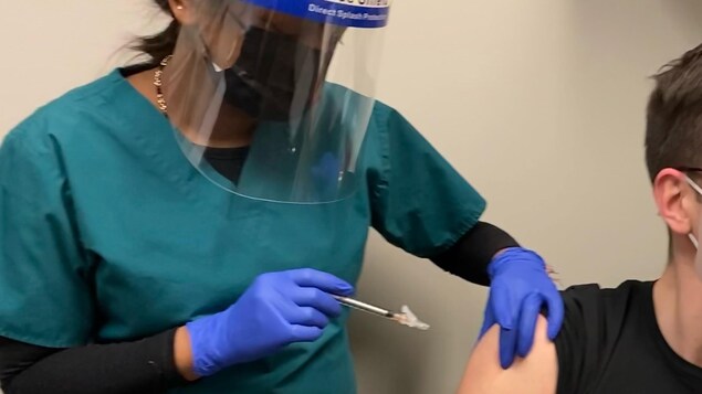 Un bénévole se fait injecter une dose du vaccin à l'essai.