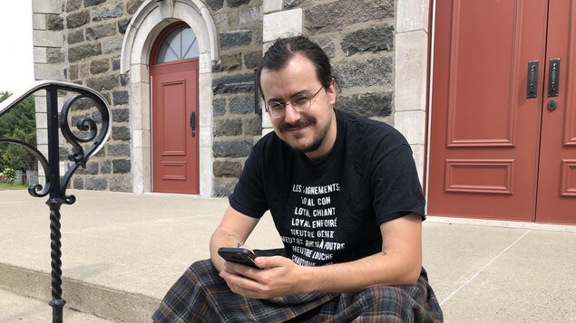 Alexandre Cormier assis sur les marches d'un escalier.