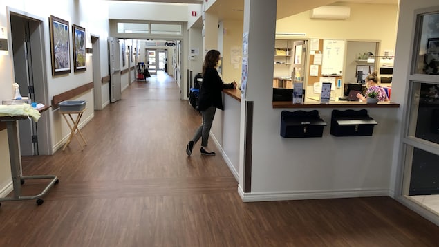 Deux employées dans leur espace de travail près d'un long corridor