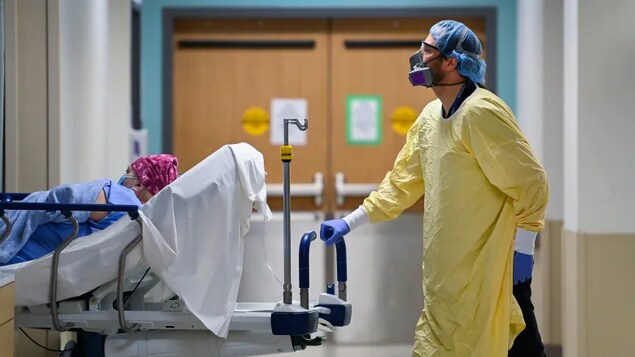 A health-care worker transports a patient in the dialysis unit at Toronto's Humber River Hospital. The hospital was the target of a ransomware attack this June. The Communications Security Establishment (CSE), a Canadian cyber spy agency, warns attacks like it will likely continue.