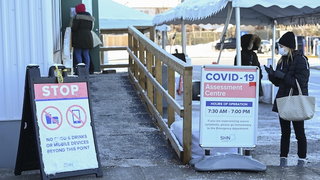 Des gens en file à l'extérieur d'un centre de dépistage à Toronto.