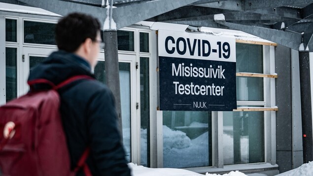 A man walks past a sign for a Covid-19 test centre in Nuuk, Greenland.