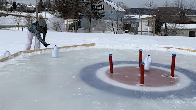 Une fille lance un bidon sur une patinoire.
