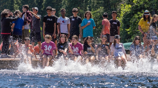 Des jeunes s'éclaboussent au bord d'un lac.