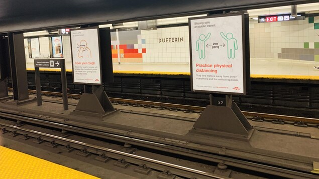Des affiches sur les rails de métro de Toronto rappellent les bonnes pratiques à adopter pendant la pandémie. Comme de garder les deux mètres de distance entre les usagers, ou de rester chez soi si l'on se sent malade.