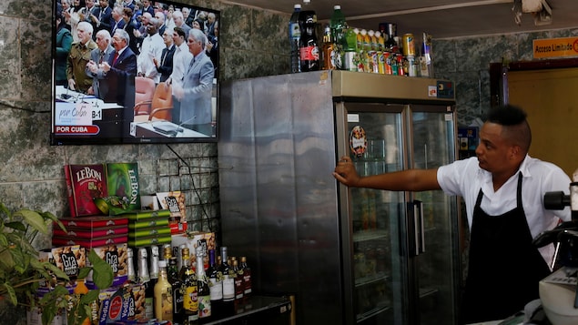 Un homme regarde une télévision qui retransmet les travaux de l'Assemblée nationale cubaine, le 18 avril 2018. Un homme regarde une télévision qui retransmet les travaux de l'Assemblée nationale cubaine, le 18 avril 2018.