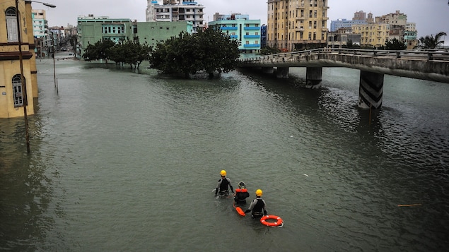 Des secouristes sont photographiés de haut en train de marcher dans la capitale cubaine inondée.