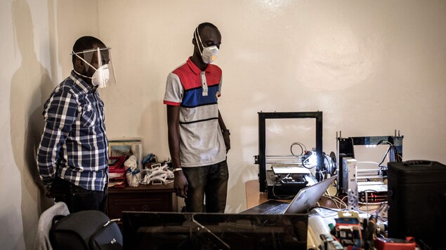 Deux hommes portant des masques de protection dans un bureau.