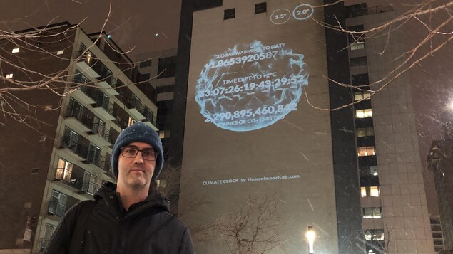 Damon Matthews devant le mur où est projetée l'horloge climatique. Damon Matthews devant le mur où est projetée l'horloge climatique.
