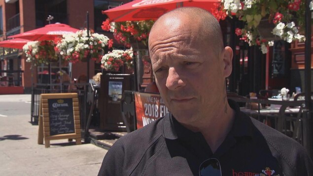Un homme devant un bar du marché By à Ottawa en entrevue. Un homme devant un bar du marché By à Ottawa en entrevue.