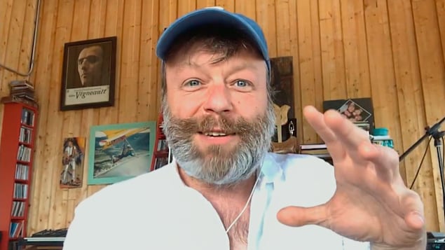 Capture d'écran d'une conversion vidéo avec Daniel Boucher, qui porte une barbe et une casquette bleue. 