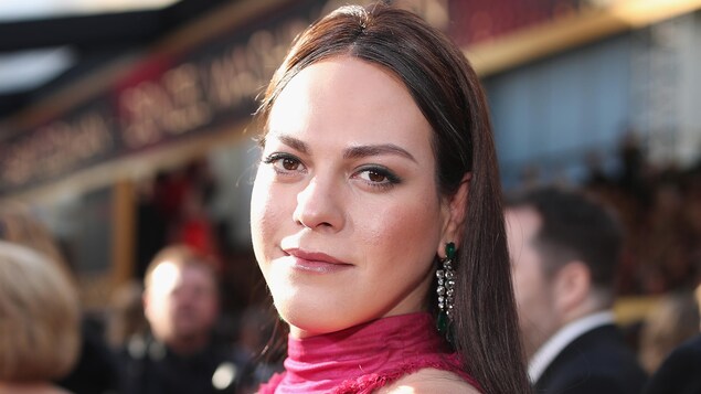 L'actrice chilienne Daniela Vega, vêtue d'une robe rose, regarde la caméra
