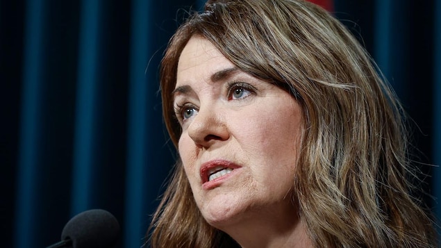 Closeup of Danielle Smith speaking into a microphone.