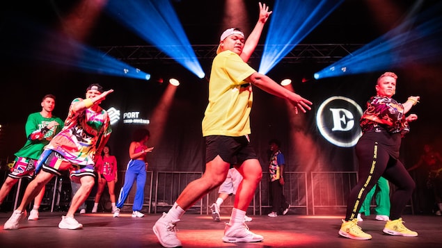 Des personnes dansent la zumba sur une scène.