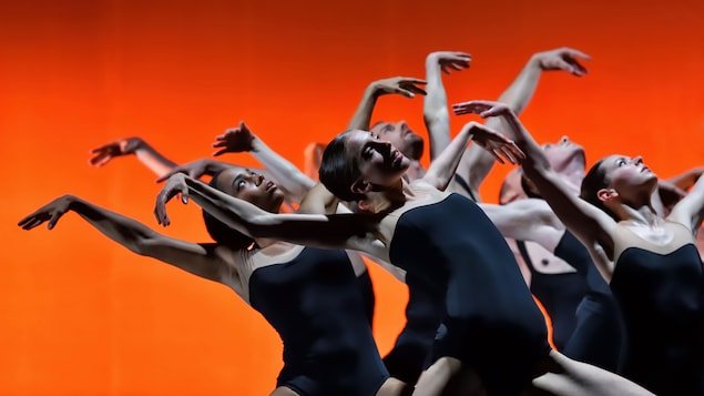 Des danseuses élèvent leurs bras dans les airs et se penchent vers leur droite en regardant le ciel.