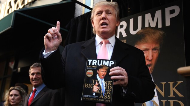 Donald Trump tient une copie de son livre. Donald Trump tient une copie de son livre.