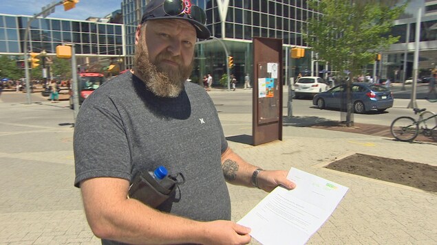 Darin Lanigan tient une lettre de la Société d’assurance du gouvernement de la Saskatchewan (SGI).