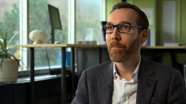 On voit le Dr Ellemberg en gros plan, assis, qui parle à la caméra. On voit le Dr Ellemberg en gros plan, assis, qui parle à la caméra.