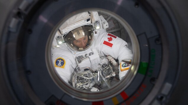 David Saint-Jacques aperçu au travers d'un hublot de la Station spatiale internationale.