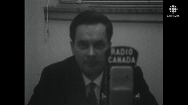 Plan buste de Davidson Dunton qui livre un discours derrière un micro de Radio-Canada.