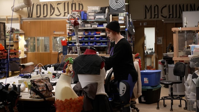 Une femme travaille sur un costume dans un atelier