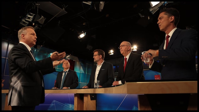 Quatre hommes autour d'une table, sur un plateau de télévision Quatre hommes autour d'une table, sur un plateau de télévision