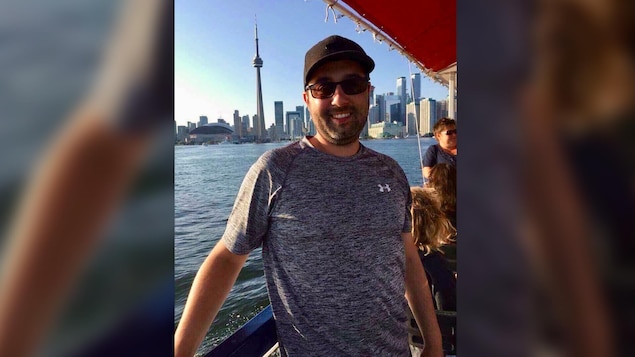 Un homme de 30 ans sur un bateau devant des immeubles à Toronto.
