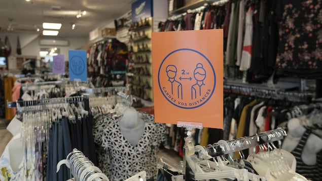 Un magasin où l'on voit des affiches demandant aux clients de garder leurs distances.