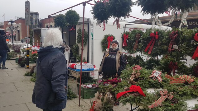 Une femme regarde l'étalage de décoration de Noël dans le marché By.
