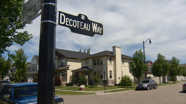 Panneau qui indique « Decoteau Way », ou rue Decoteau; en arrière-plan : des maisons, dans un quartier résidentiel d'Edmonton Panneau qui indique « Decoteau Way », ou rue Decoteau; en arrière-plan : des maisons, dans un quartier résidentiel d'Edmonton