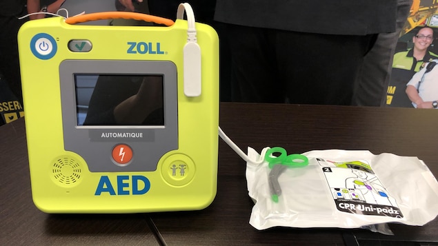 Un défibrillateur cardiaque automatique est posé sur une table.