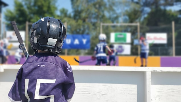 De jeunes enfants jouent au dek hockey dans un cours.