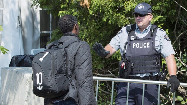 Un demandeur d'asile et un agent de la GRC à la frontière canado-américaine.