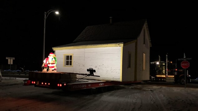 La maison est déplacée sur la remorque d'un camion en pleine nuit. 