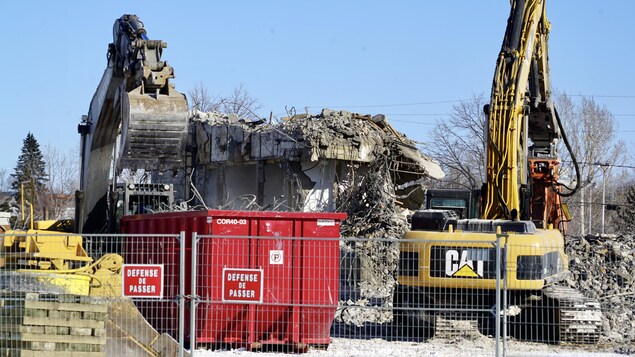 Des tracteurs, un conteneur et des ruines.